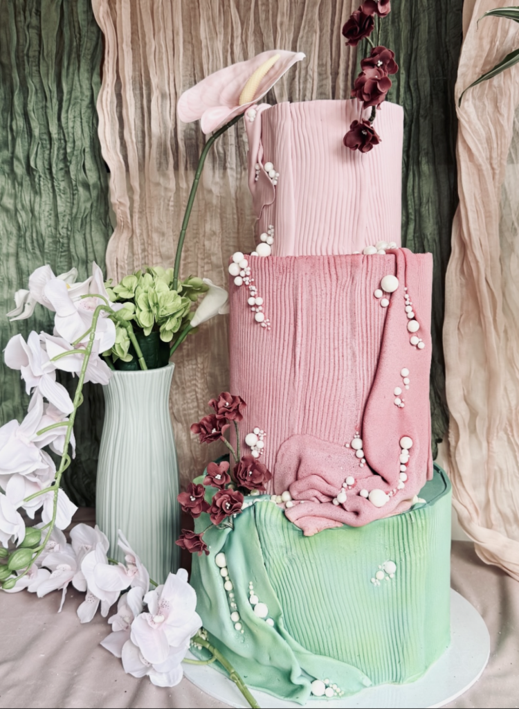 Colourful modern wedding cake in pink and green with sculptural sugar flowers, designed by Crumbdidilyumptious in Scotland