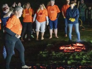 Kerrie alongside participants crossing the coals