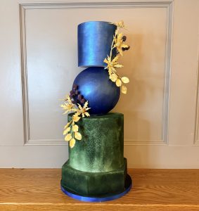 Bespoke sculptural wedding cake with blue sphere and gold thistle detailing for Edinburgh luxury weddings.