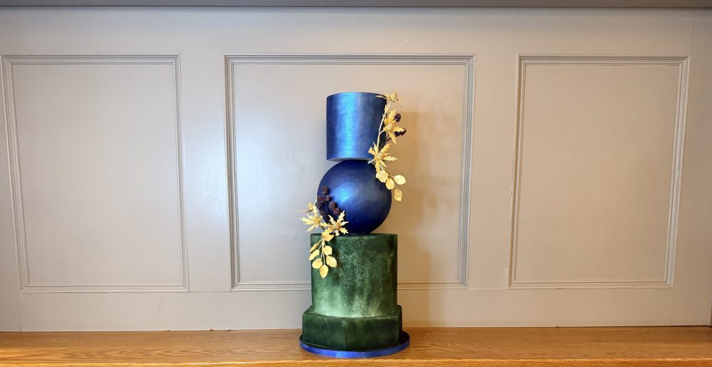 Bold sculptural luxury wedding cakes, Architectural wedding cake installation featuring metallic blue sphere and forest green tiers for luxury Scottish industrial venues