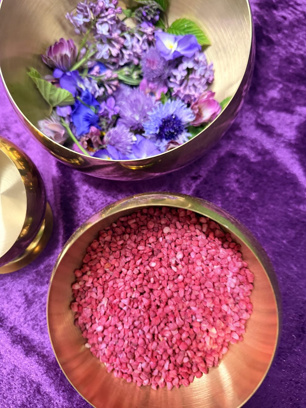 Interactive botanical apothecary performance for luxury weddings in Scotland featuring lilac flowers and pink edible textures in brushed gold bowls on purple velvet for luxury destination wedding cakes Scotland