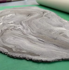 Rolling out hand-distressed stone textures for bespoke wedding cakes.