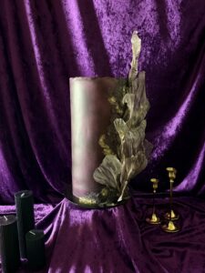 Dramatic sculptural wedding cake with black edible lace, metallic gold detailing and wafer paper sails by Crumbdidilyumptious. 
