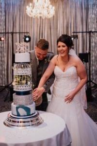 Bride beside her bespoke blue, silver and white wedding cake with a birdcage tier